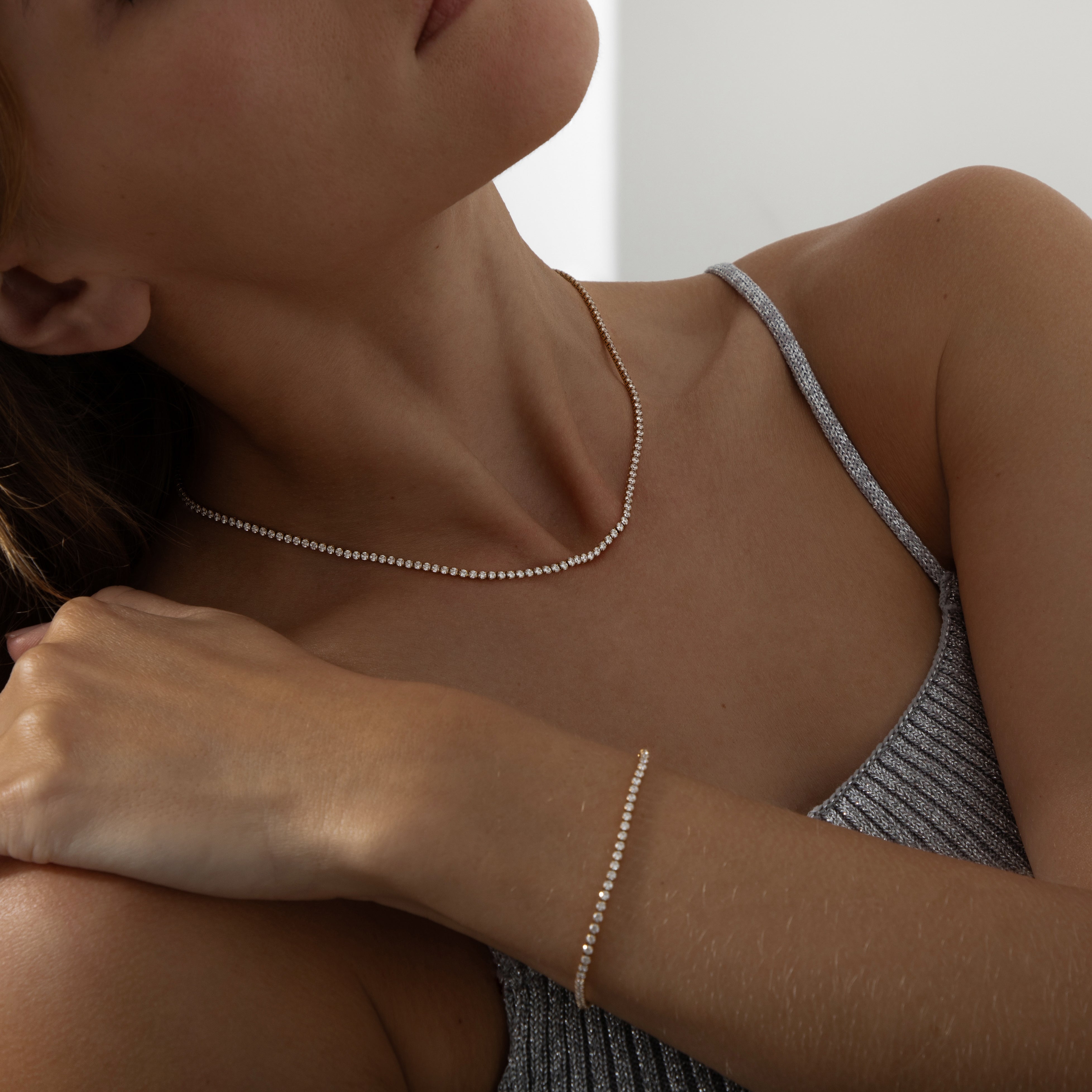 Gold dainty tennis necklace featuring a continuous line of sparkling round-cut cubic zirconia stones on a delicate chain