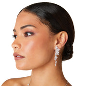 Silver long drop earrings with cascading floral embellishments, tapering to a delicate point; sparkling statement jewelry perfect for weddings, holidays, and special occasions.