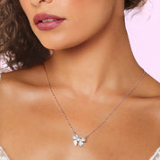 Close-up of silver bow necklace showing polished bow loops and chain clasp detail