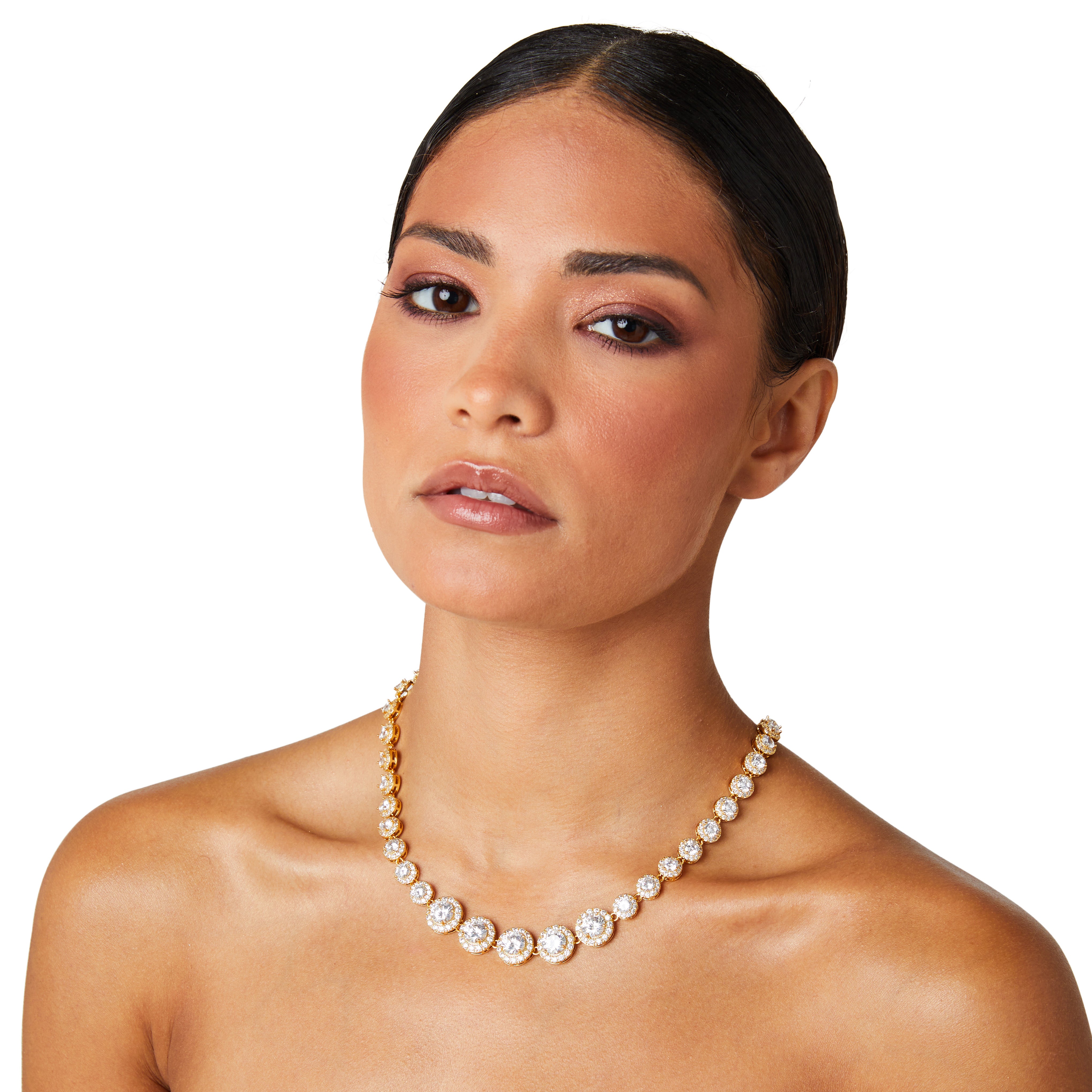 Model wearing a gold crystal tennis necklace featuring graduated cubic zirconia stones with pavé halos, styled with a minimalist outfit to highlight the necklace's elegant sparkle