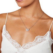 Model wearing sterling silver bow necklace, elegant pendant resting at the collarbone