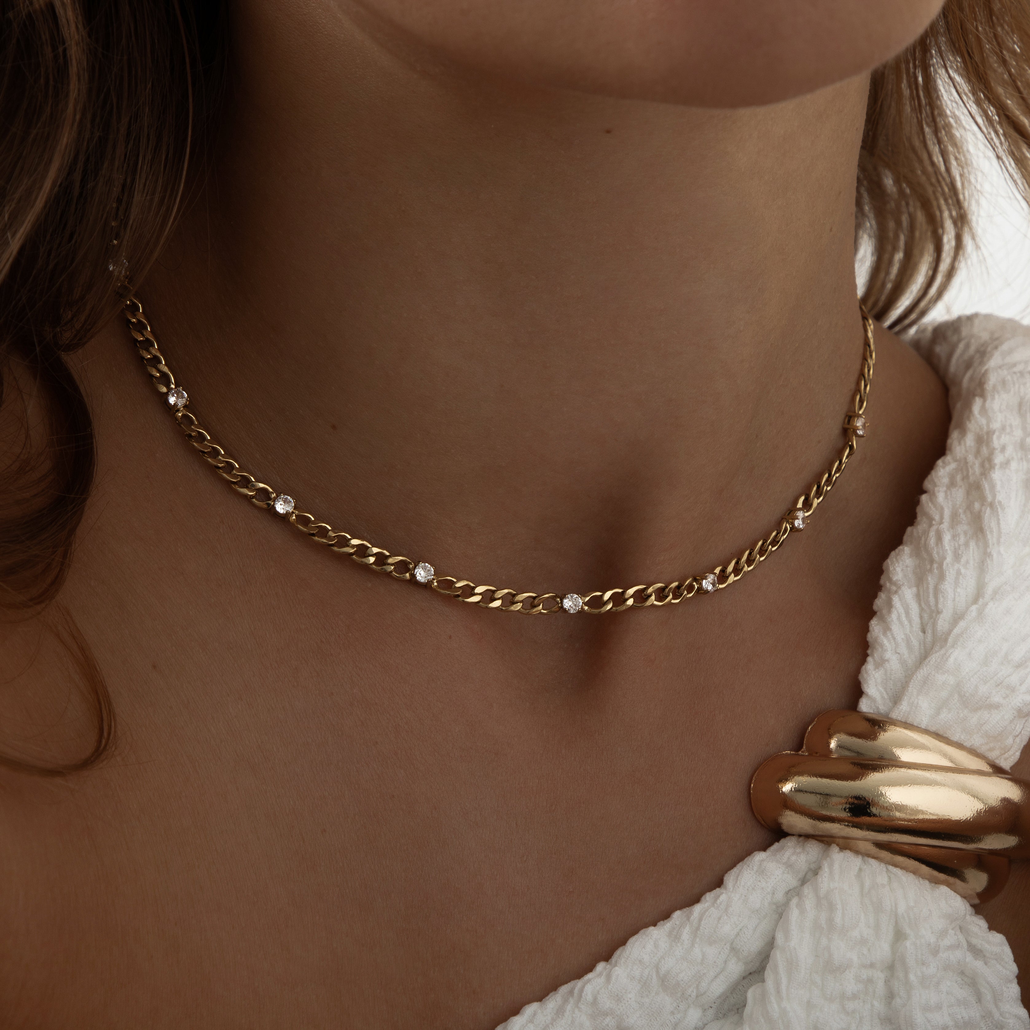 Elevate your everyday look with the Chain of Lights Necklace – an 18K gold-plated stainless steel chain adorned with 8 cubic zirconia crystals. Waterproof, sweatproof, and perfect for layering, this dainty yet durable necklace brings lasting sparkle to every outfit.