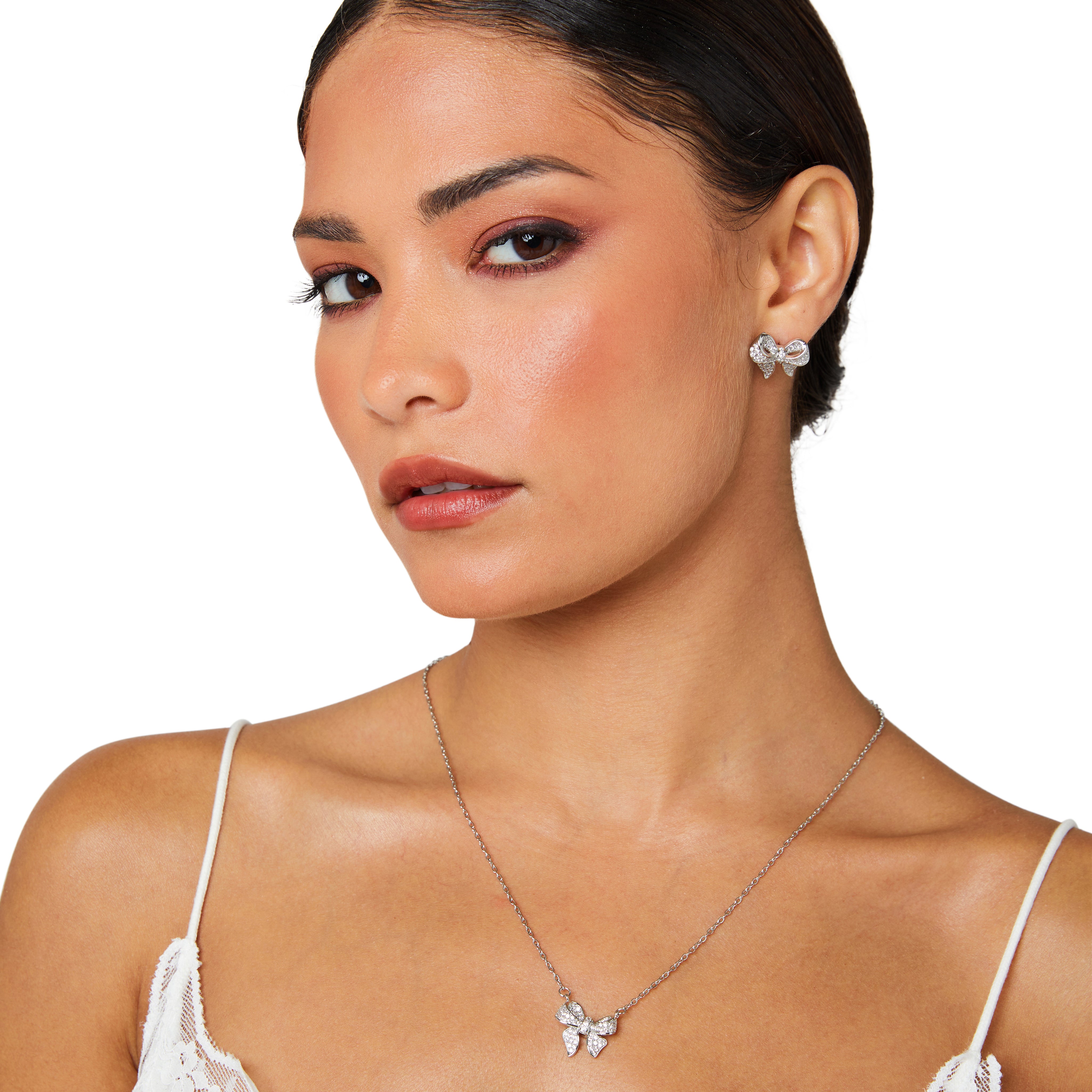 Model wearing sterling silver bow necklace, elegant pendant resting at the collarbone