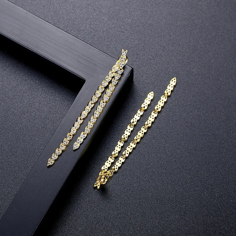Gold reversible strand earrings, Two-strand gold crystal embellished earrings, Front and back wearable gold earrings, Sleek polished gold earrings with crystal detail, Trendsetting gold earrings as seen on Tess Daly, Modern gold earrings with playful sparkle, Elegant gold earrings with shimmering strands