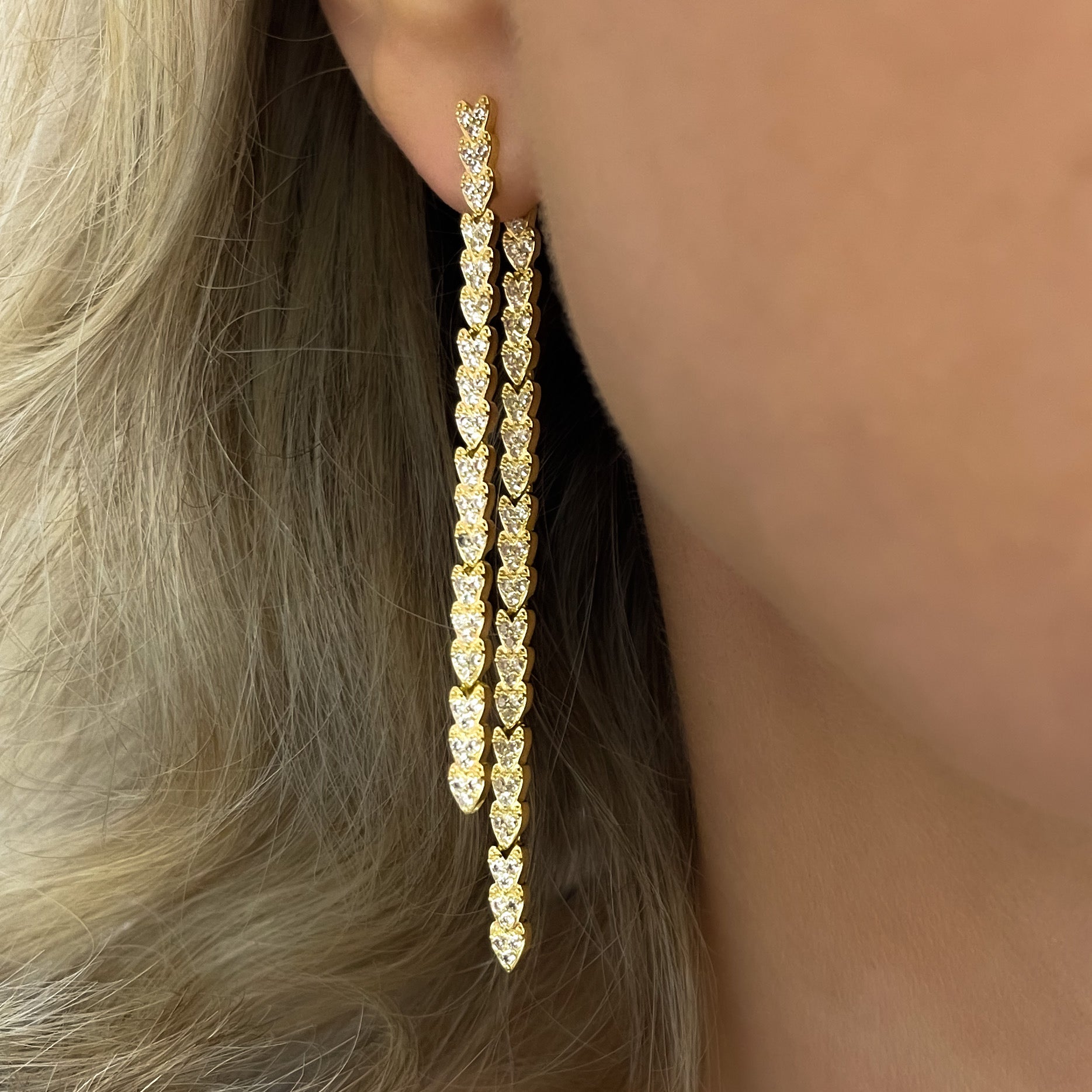 Gold reversible strand earrings, Two-strand gold crystal embellished earrings, Front and back wearable gold earrings, Sleek polished gold earrings with crystal detail, Trendsetting gold earrings as seen on Tess Daly, Modern gold earrings with playful sparkle, Elegant gold earrings with shimmering strands