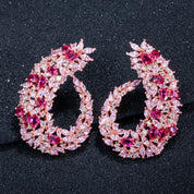 Rose gold drop earrings inspired by Japanese cherry blossoms, featuring marquise pink crystals and a sleek, curvy design for elegant statement style.