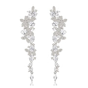 Silver long drop earrings with cascading floral embellishments, tapering to a delicate point; sparkling statement jewelry perfect for weddings, holidays, and special occasions.