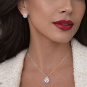 Close-up of a model wearing pear cut  earrings and necklace.