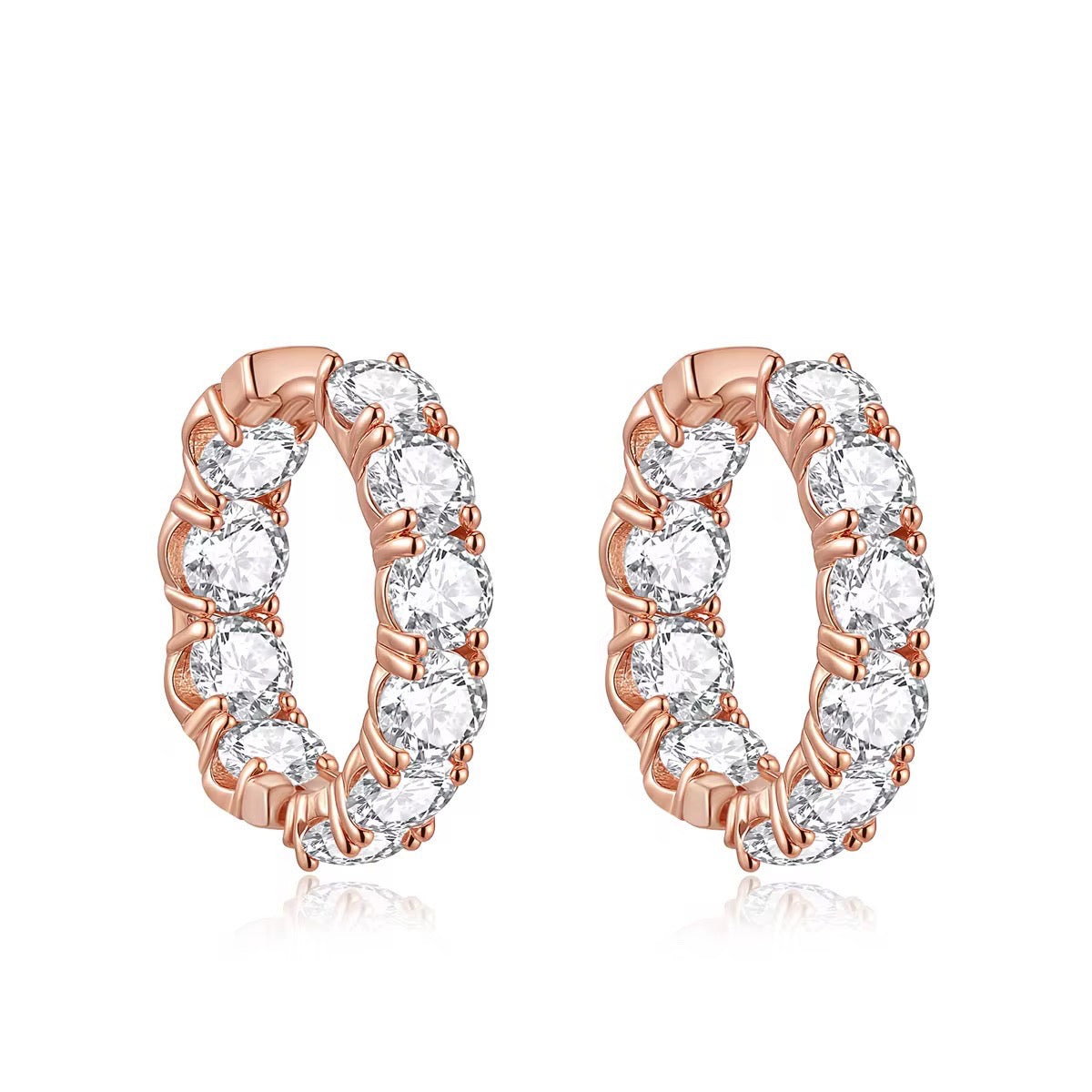 Rose gold hoop earrings with clear gemstones on a white background