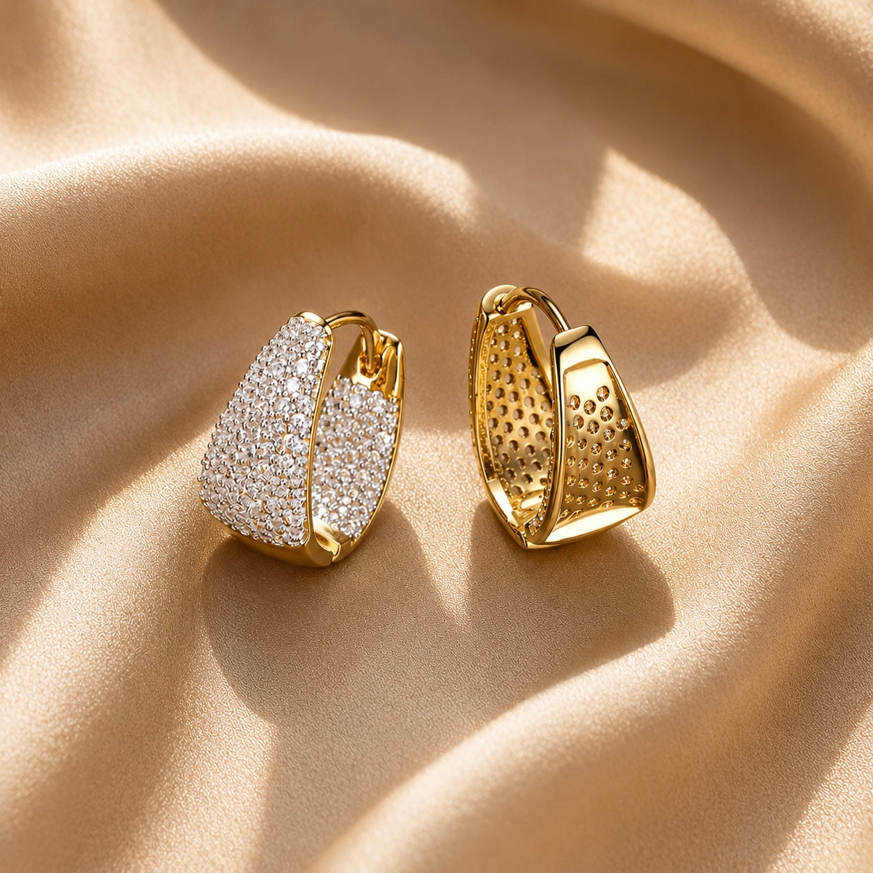 Gold hoop pave earrings with a beige fabric