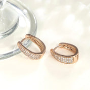 Rose gold huggie hoop earrings with pavé cubic zirconia, gently domed and polished for subtle sparkle. Medium-small size (1.7cm), shown in eco-friendly Valentina Rose gift box.