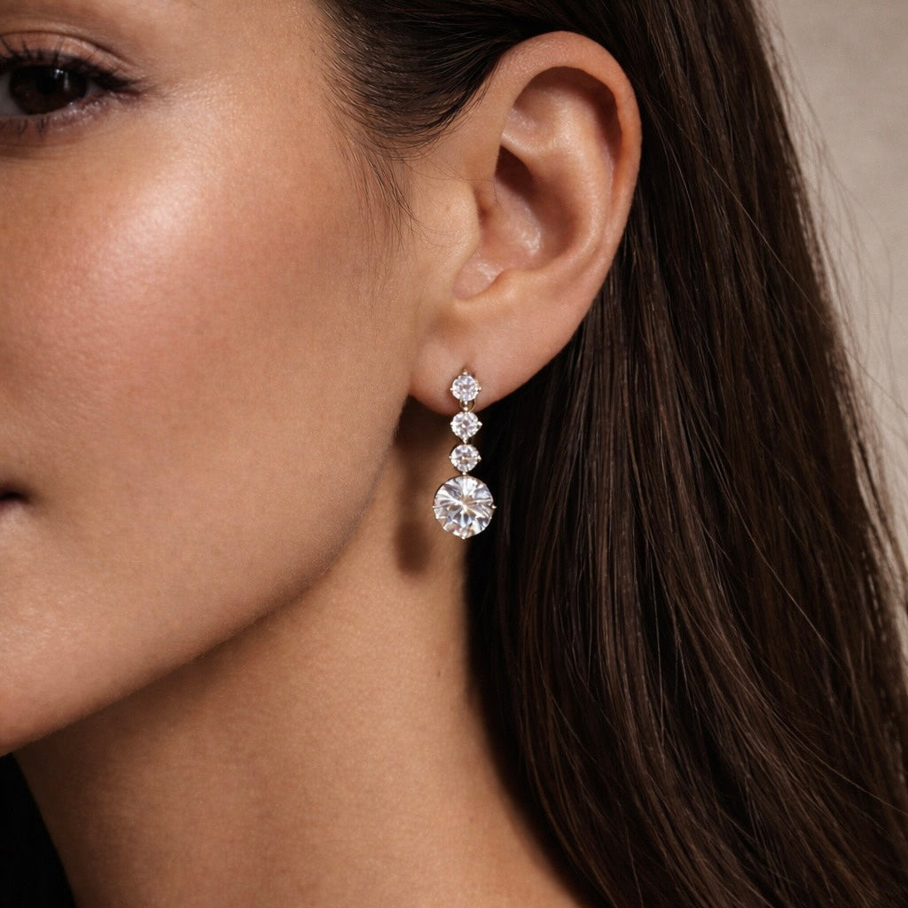 Close-up of a woman wearing crystal wedding earrings with a neutral background