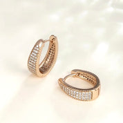 Rose gold huggie hoop earrings with pavé cubic zirconia, gently domed and polished for subtle sparkle. Medium-small size (1.7cm), shown in eco-friendly Valentina Rose gift box.