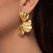 18k gold plated stainless steel with hammered finish, Gold leaf-shaped statement earrings with textured surface, Tropical-inspired hammered gold earrings with reflective detail, Sculptural gold earrings with nature-inspired leaf design, Elegant hammered gold earrings with modern tropical style