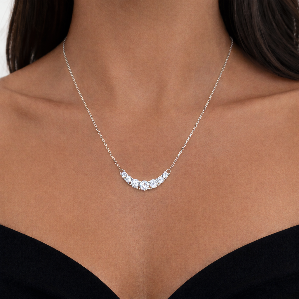 Silver curved bar necklace with round cubic zirconia stones on a delicate chain, shown on a model
