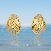 A pair of gold‑plated stud earrings, each shaped like three elegant, tapering wave arches that fan outward in a stylised, goddess-inspired design. The curved strands are smooth, mirror‑polished, and evenly spaced, creating a sense of movement and volume while remaining compact—approximately 1.3 cm tall from post to tip. They appear to sit snugly along the earlobe and fasten with standard push-back posts. The warm metallic sheen and sculptural silhouette evoke a graceful, contemporary luxury vibe.