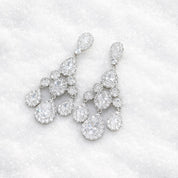 Pair of diamond like earrings on a winter snow background