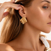 Model wearing gold molten earrings.