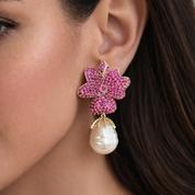 Close-up of a woman wearing pink floral earrings with a pearl drop Valentina Rose jewellery 