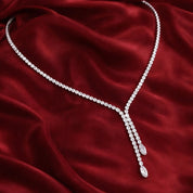 Lariat necklace on a burgundy fabric background