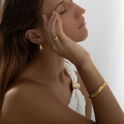 Pair of 18k gold-plated stainless steel hoop earrings, each adorned with a celestial design featuring sparkling stars, a crescent moon, and a radiant sunburst. Delicately inlaid with shimmering AAA cubic zirconia crystals to evoke a night sky effect. Lightweight, waterproof, tarnish-free, and hypoallergenic—crafted for all-day, everyday elegance.