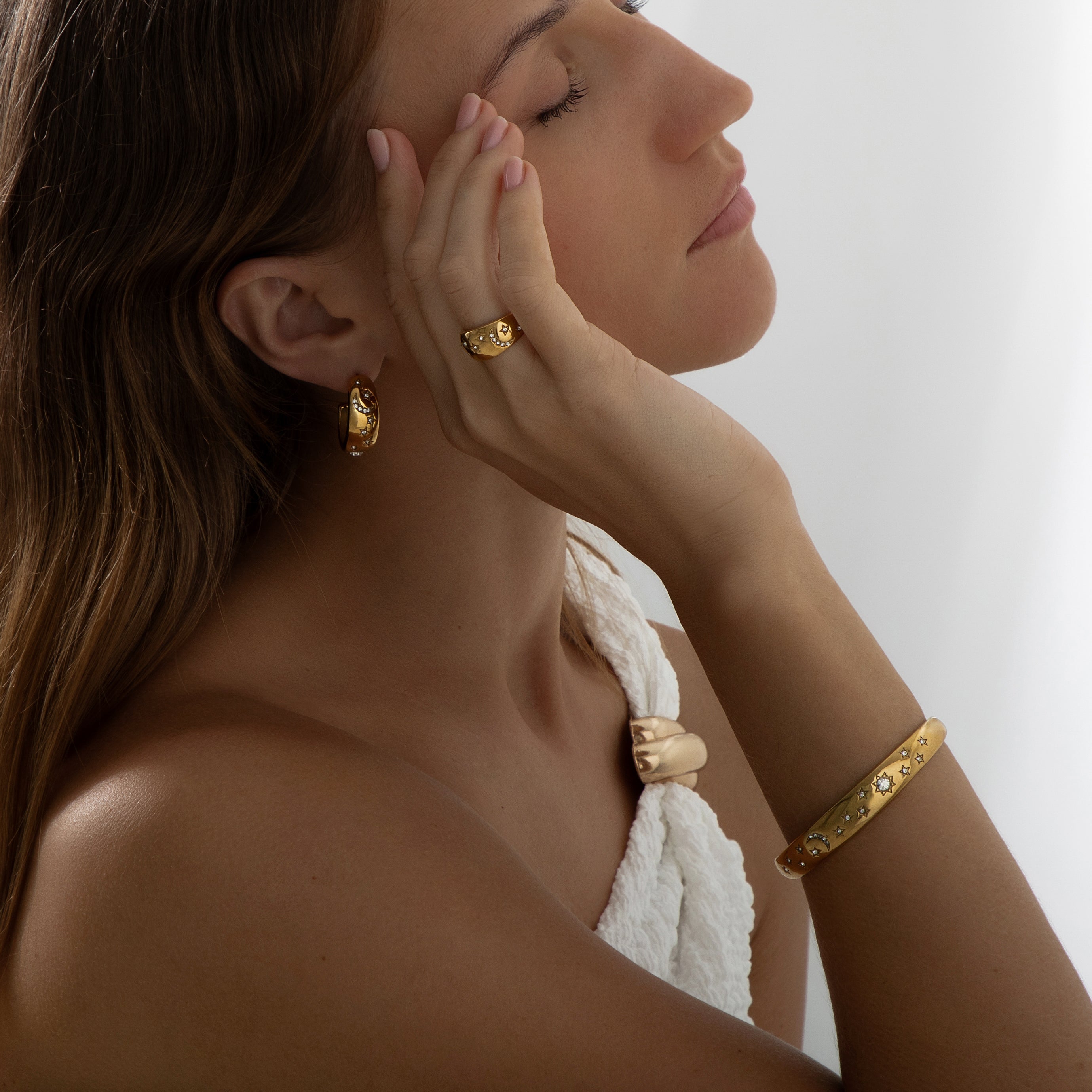 Pair of 18k gold-plated stainless steel hoop earrings, each adorned with a celestial design featuring sparkling stars, a crescent moon, and a radiant sunburst. Delicately inlaid with shimmering AAA cubic zirconia crystals to evoke a night sky effect. Lightweight, waterproof, tarnish-free, and hypoallergenic—crafted for all-day, everyday elegance.