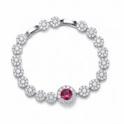 Silver bracelet with a central red gemstone on a white background