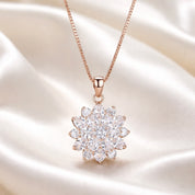 Rose gold necklace with a marquise cluster pendant on a satin background