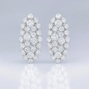 Pair of diamond like oval icy earrings on a light gray background