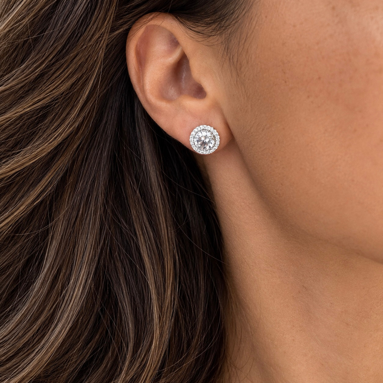 Model wearing round sterling silver halo stud earrings with brilliant clear cubic zirconia – Valentina-Rose