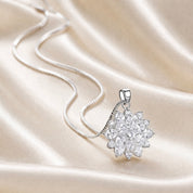 Silver necklace with a floral cluster pendant on a satin background