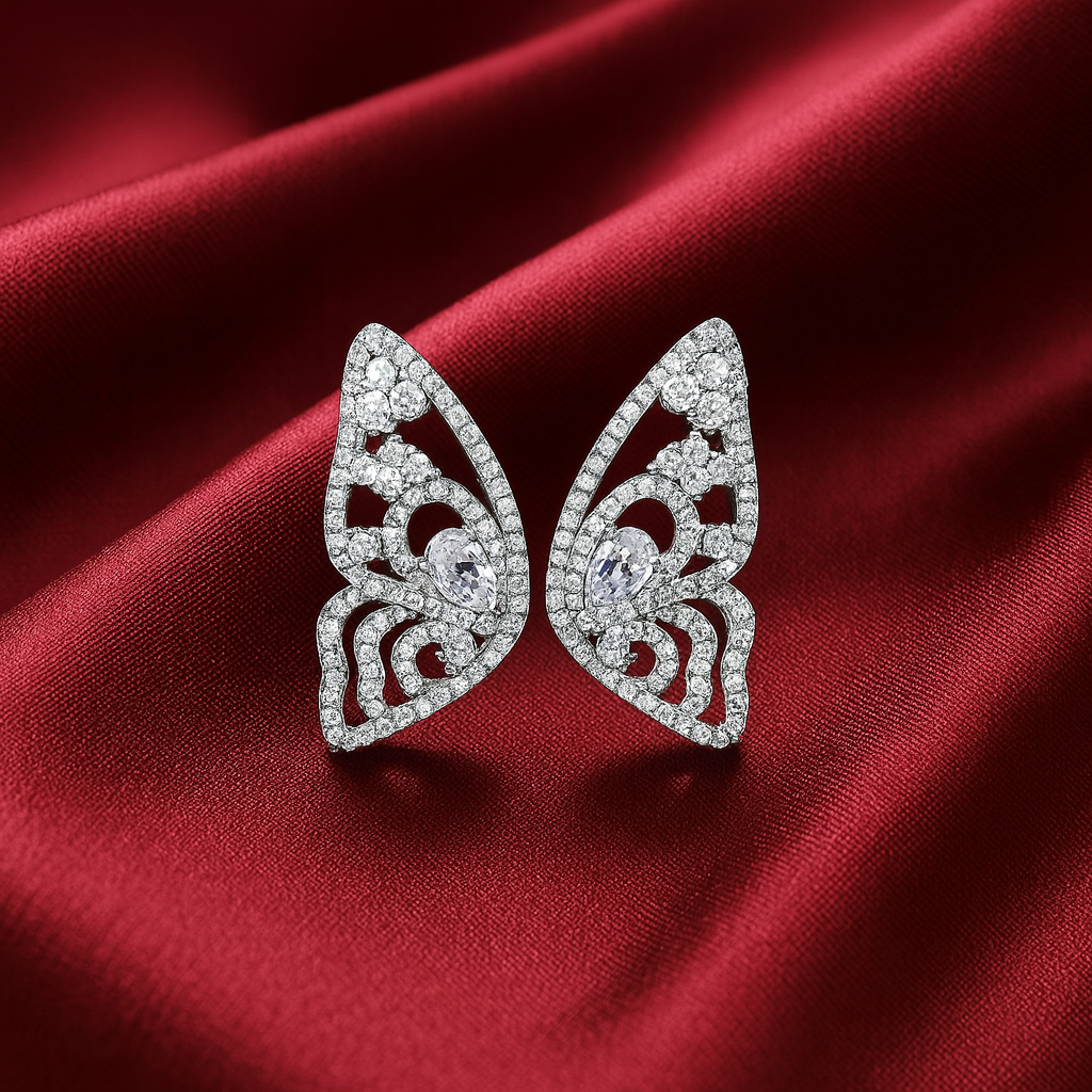 Butterfly-shaped  pave zircon earrings on a red satin background