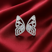 Butterfly-shaped  pave zircon earrings on a red satin background