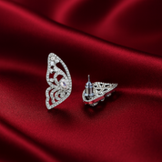 Butterfly-shaped pave cubic zirconia earring  on a red fabric background