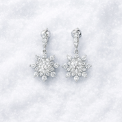 Snowflake-shaped earrings with clear stones on a white background