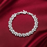 Silver vine bracelet with leaf-shaped diamonds on a red fabric background