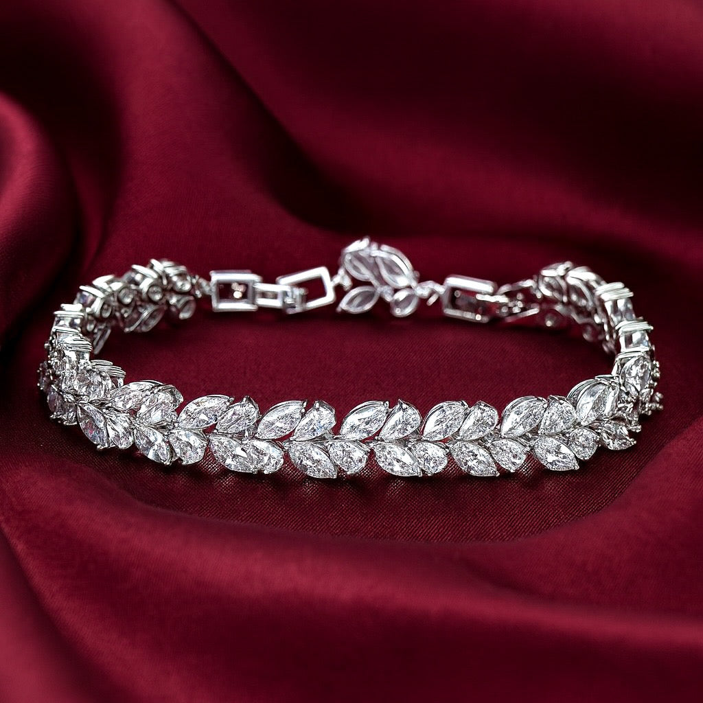 Silver vine bracelet with leaf-shaped crystals on a red fabric background