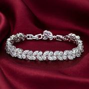 Silver vine bracelet with leaf-shaped crystals on a red fabric background