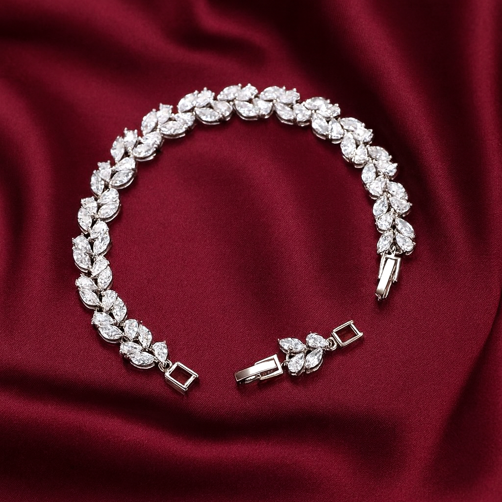 Silver vine leaf bracelet with diamond-like stones on a red fabric background