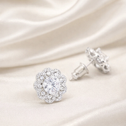 Silver earrings with clear gemstones on a soft white fabric background