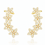 Gold and clear flower shaped earrings on a white background
