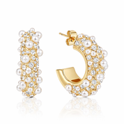 Gold hoop earrings with pearls and crystals on a white background