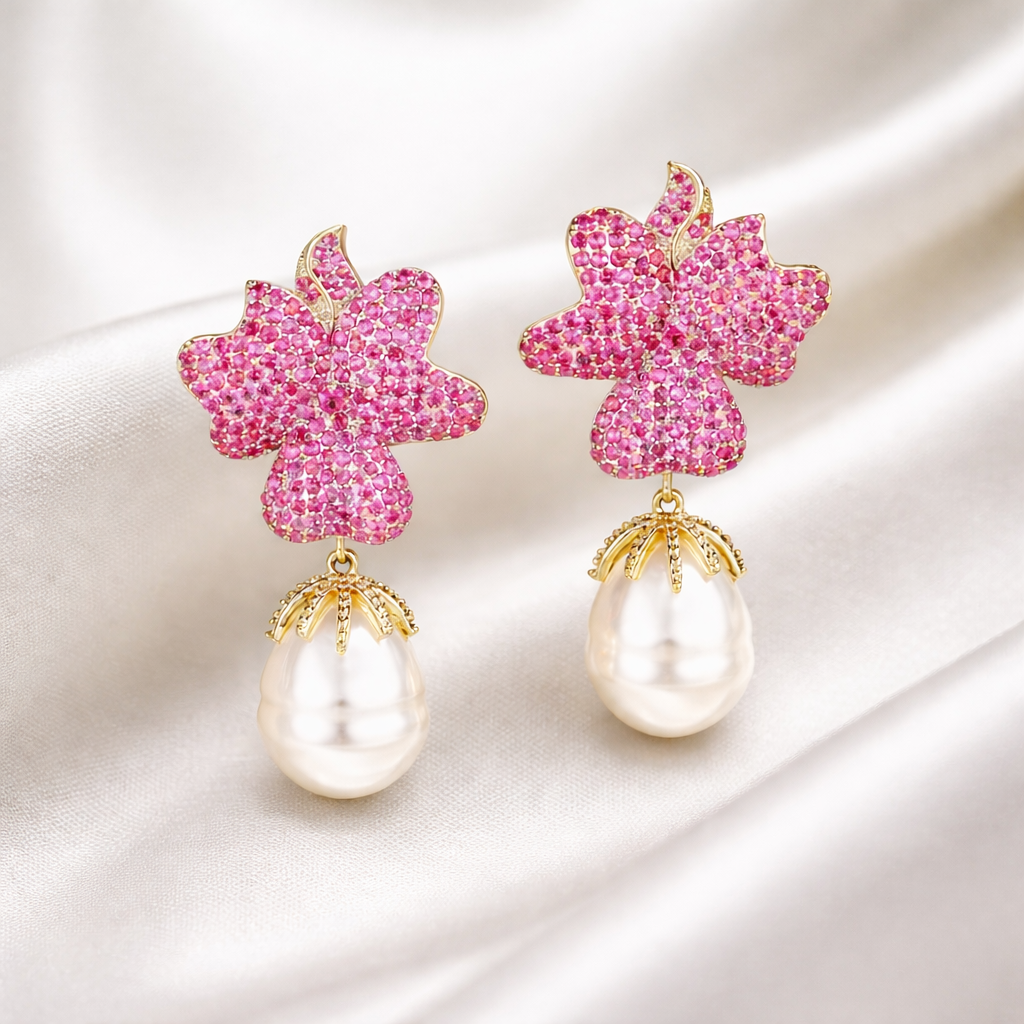 Pink flower-shaped earrings with pearl drops on a white background