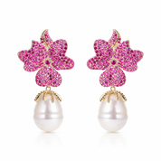 Pair of earrings with pink floral top and pearl bottom on a white background