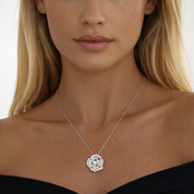 Close-up of a woman wearing a silver necklace with a floral pendant.