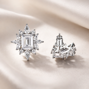 Luxury emerald cut crystal halo stud earrings with marquise cluster design in silver on ivory silk fabric